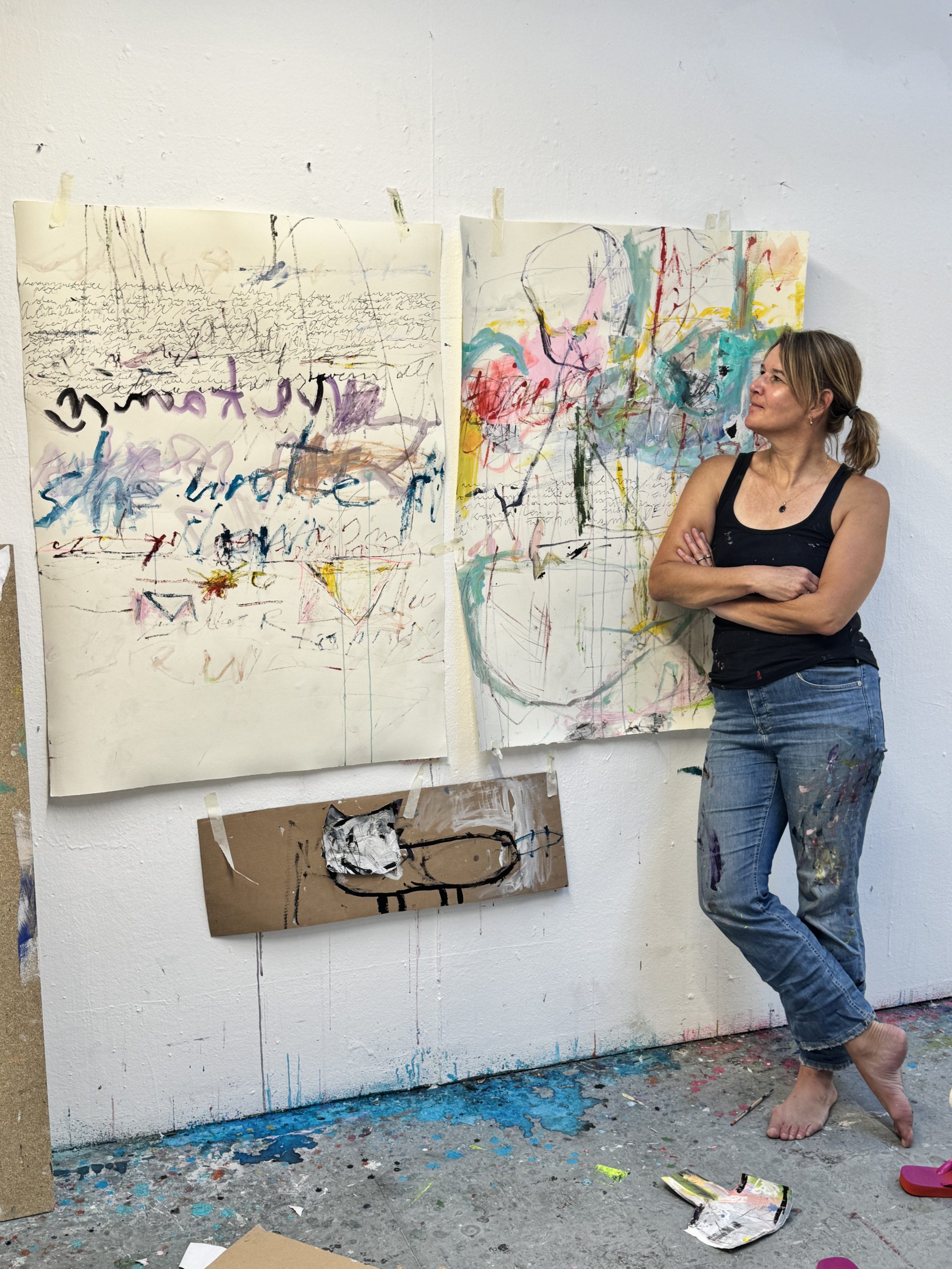 Claudia Keupen in ihrem Atelier auf Mallorca, vor ihren Arbeiten stehend